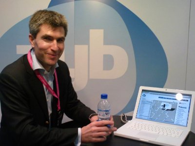 A man standing next to a laptop showing the Zyb website