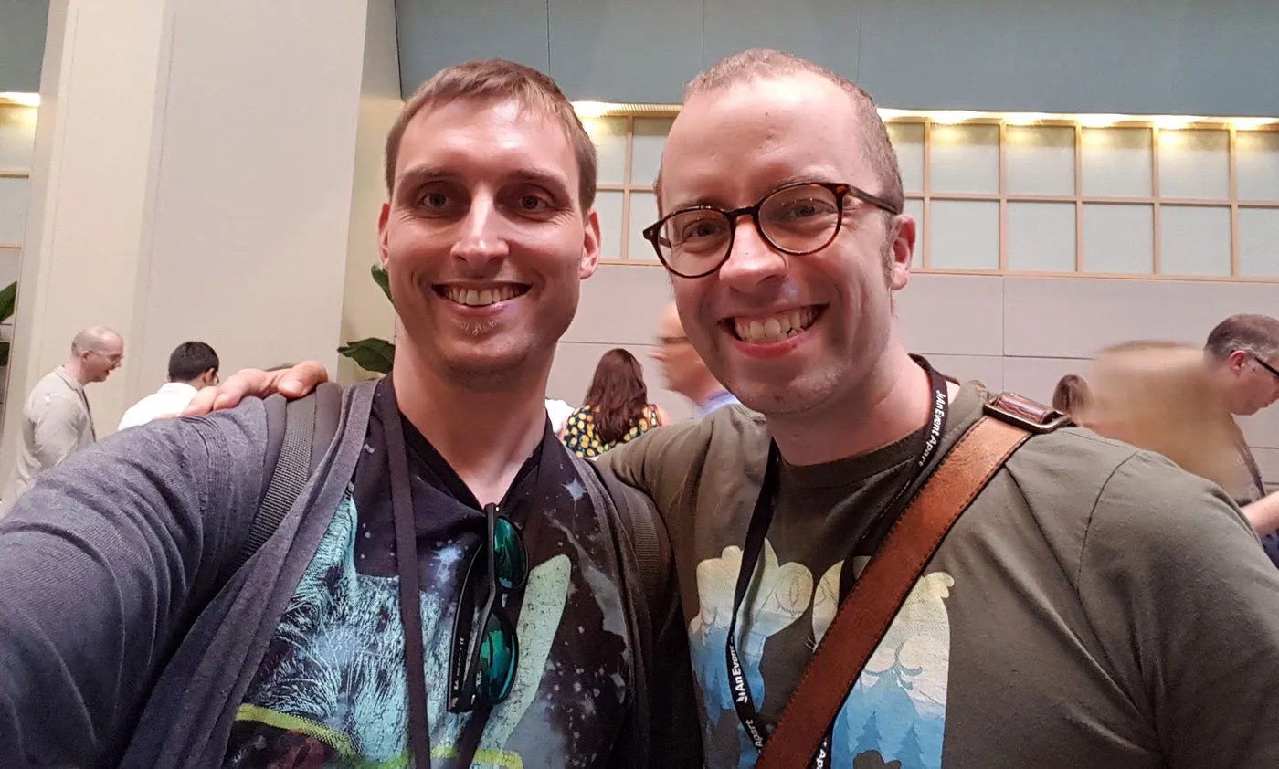 Me posing with Ethan Marcotte. I'm grinning again, as is he. We're both wearing T-shirts with designs printed on them. Mine's got a cat's head in space shooting lasers from its eyes. His has some kind of silhouette filled with a foresty, mountainous landscape. We're the same height.