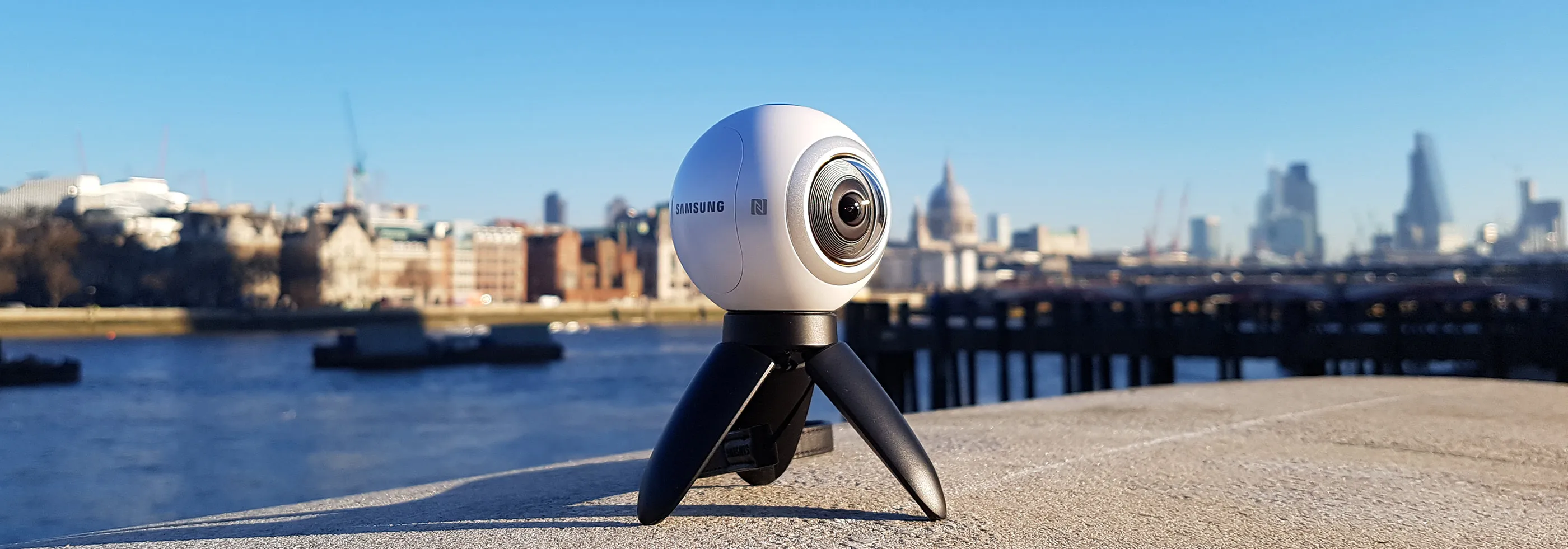 Samsung Gear360 camera standing on a wall by the Thames in central London on a sunny day