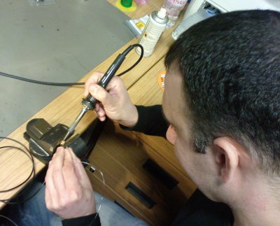 Angelo, an engineer at Symbian, is soldering a plug onto a cable