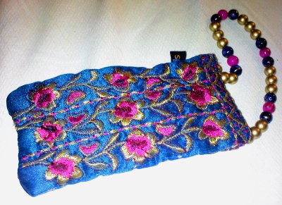 A blue pouch with a colourful flower pattern embroidered onto it