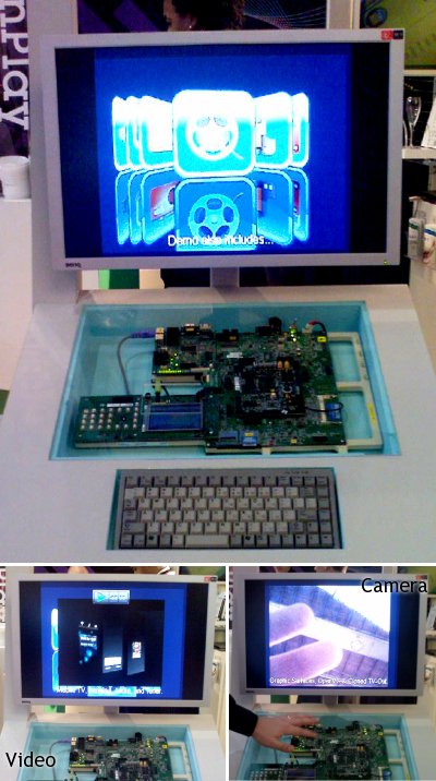 The ScreenPlay tech demo at the Symbian booth. A development board is visible behind a glass panel. Below it is a keyboard and above it is a monitor. A carousel of icons is visible on the monitor. 2 additional photos show parts of the demo in action on the montiro: A video overlaid on the carousel menu, and a live camera viewfinder