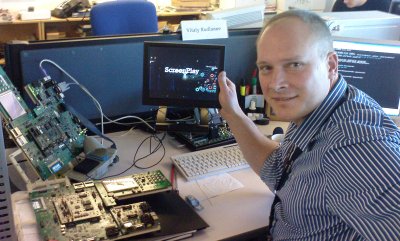 Vitaly, a developer at Symbian, holds up a monitor displaying the demo that is connected to a development board